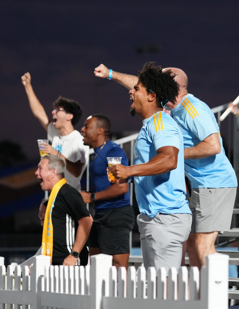 Group of fans cheering at a Sporting JAX game.
